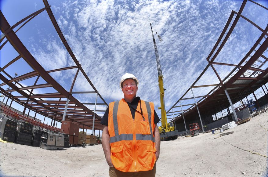 In this April 23, 2021 photo, Zeke Kaney, the current Hobbs Municipal Schools Director of Operations and newly named Director of Career and Technical Education, stands between the two wings of a new learning facility under construction in Hobbs, N.M. When completed, officials say the Hobbs Career and Technical Education Center, or CTECH, will be the premiere vocational education facility of its kind in the region. (Blake Ovard/The Hobbs Daily News-Sun via AP)