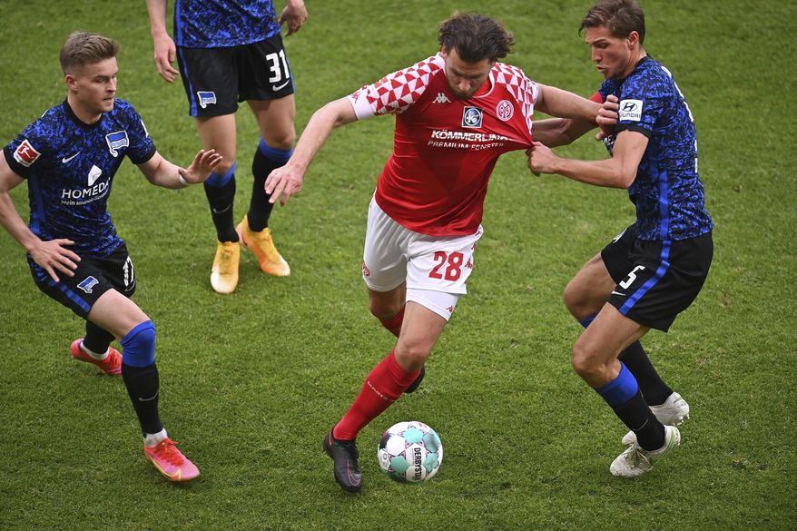 Mainz's Adam Szalai, center, in action against Hertha's Niklas Stark, right, during the German Bundesliga soccer match between FSV Mainz 05 and Hertha BSC in Mainz, Germany, Monday, May 3, 2021. (Torsten Silz/dpa via AP)