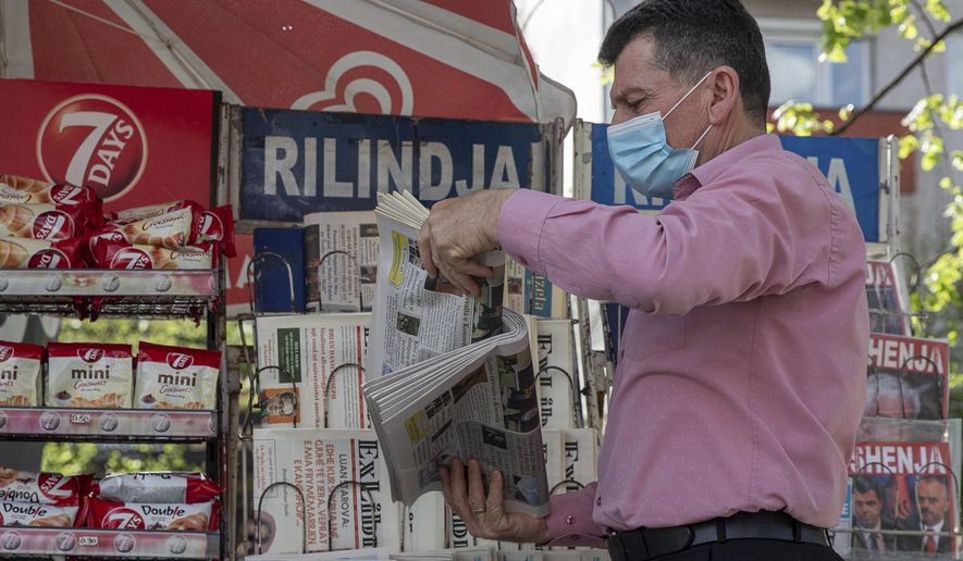 Vendor Ibrahim Gashi, arranges weekly and monthly magazines at his newspaper kiosk were he has been selling newspapers downtown for 35 consecutive years except one, in the capital Pristina, Thursday, April 29, 2021. The printing presses stopped running at the start of the pandemic in Kosovo. The country's five dailies all stopped printing physical newspapers and turned into online media portals. But these do not reach all the people as before, and many fear they prioritise speed over accuracy. (AP Photo/Visar Kryeziu)