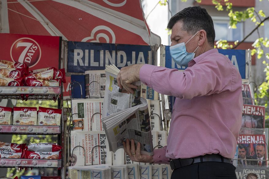 Vendor Ibrahim Gashi, arranges weekly and monthly magazines at his newspaper kiosk were he has been selling newspapers downtown for 35 consecutive years except one, in the capital Pristina, Thursday, April 29, 2021. The printing presses stopped running at the start of the pandemic in Kosovo. The country's five dailies all stopped printing physical newspapers and turned into online media portals. But these do not reach all the people as before, and many fear they prioritise speed over accuracy. (AP Photo/Visar Kryeziu)