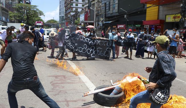 Anti-coup protesters burn tires and chant slogans with banner read &#x27;&#x27;The Kamayut strike will be fight for to the end when we get victory&amp;quot; during the demonstration against the military coup in Kamayut township Yangon, Monday, May 3, 2021. (AP Photo)