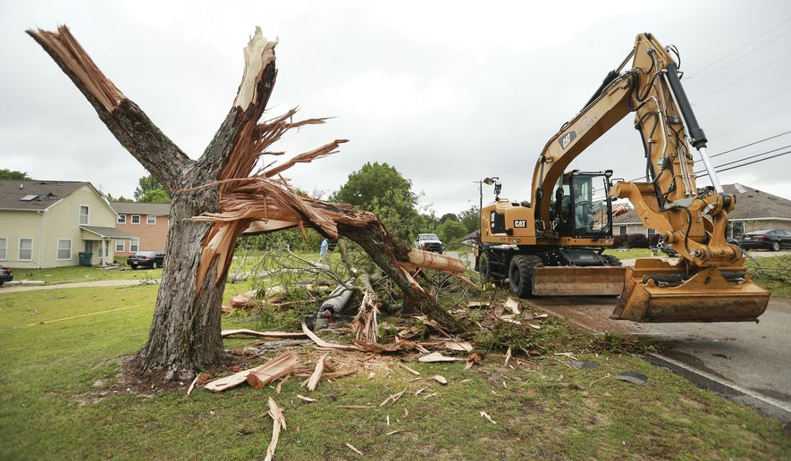 A Tupelo Public Works employee works to clear out more debris and tree limbs on Monday, May 3, 2021 after a tornado hit the area late Sunday night in Tupelo, Miss. (Adam Robison/The Northeast Mississippi Daily Journal via AP)