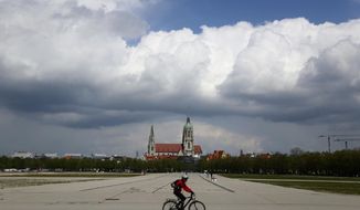 A cyclist crosses the &#39;Oktoberfest&#39; beer festival area &#39;Theresienwiese&#39; in front of the St. Pauls church in Munich, Germany, Monday, May 3, 2021. The world&#39;s largest beer festival &#39;Oktoberfest&#39; was cancelled last year due to the coronavirus outbreak. (AP Photo/Matthias Schrader)