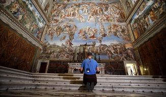 A visitor kneels in front of the Last Judgement fresco by the Italian Renaissance painter Michelangelo inside the Sistine Chapel of the Vatican Museums on the occasion of the museum&#39;s reopening, in Rome, Monday, May 3, 2021. The Vatican Museums reopened Monday to visitors after a shutdown following COVID-19 containment measures. (AP Photo/Alessandra Tarantino)