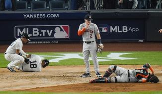 Houston Astros&#39; Alex Bregman, center, watches as New York Yankees&#39; Rougned Odor, left, and Houston Astros catcher Martin Maldonado, right, react to being injured on a play at home plate during the sixth inning of a baseball game Tuesday, May 4, 2021, in New York. (AP Photo/Frank Franklin II)