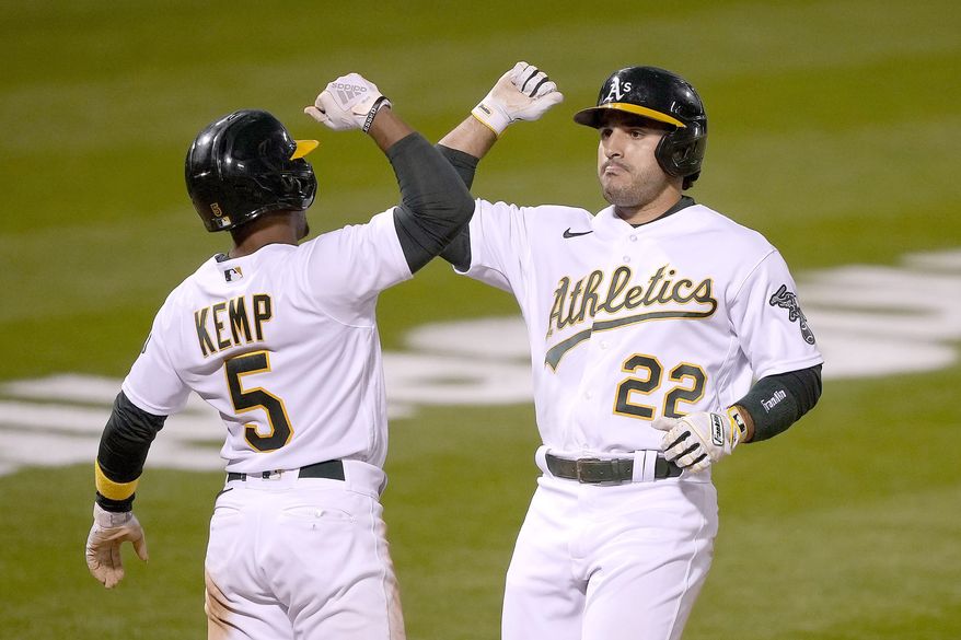 Oakland Athletics&#39; Ramon Laureano (22) gets a forearm-bash with his teammates Tony Kemp (5) after hitting a two-run home run against the Toronto Blue Jays during the fifth inning of a baseball game in Oakland, Calif., on Monday, May 3, 2021. (AP Photo/Tony Avelar)