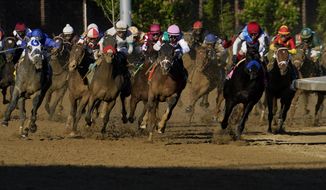 John Velazquez riding Medina Spirit, third from right, leads the field as they round the fourth turn to win the 147th running of the Kentucky Derby at Churchill Downs, Saturday, May 1, 2021, in Louisville, Ky. (AP Photo/Brynn Anderson)