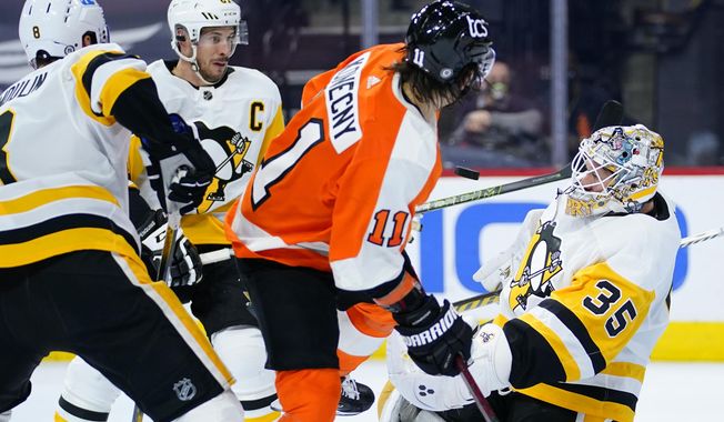 Pittsburgh Penguins&#x27; Tristan Jarry (35) blocks a shot as Sidney Crosby (87) Brian Dumoulin (8) and Philadelphia Flyers&#x27; Travis Konecny (11) look on during the third period of an NHL hockey game, Tuesday, May 4, 2021, in Philadelphia. (AP Photo/Matt Slocum)