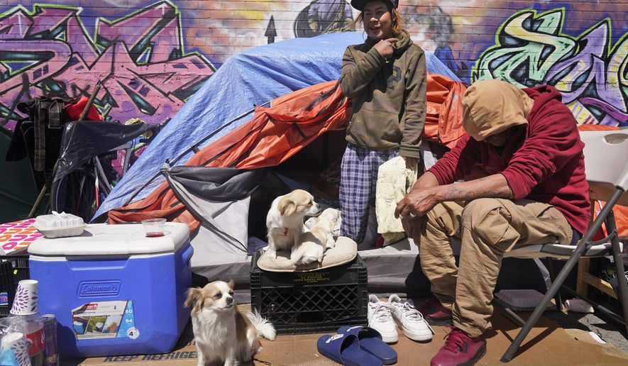 Lucio Lopez, left, talks with friends as he stands in a tent that is part of a homeless encampment in the Queens borough of New York, Tuesday, April 13, 2021. Unemployment among Hispanic immigrants has doubled in the U.S., going from 4.8% in January 2020 to 8.8% in February 2021, according to the Migration Policy Institute. These numbers don’t take into consideration immigration status but activists and social workers in states like New York or California say more vulnerable immigrants, whom often don&#39;t qualify for aid, are finding themselves without a home. (AP Photo/Seth Wenig)