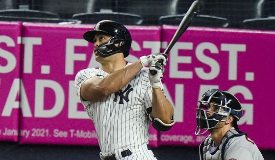 New York Yankees&#39; Giancarlo Stanton follows through on a two-run home run during the third inning of a baseball game against the Houston Astros Wednesday, May 5, 2021, in New York. (AP Photo/Frank Franklin II)