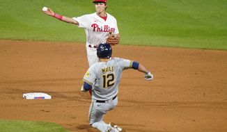 Philadelphia Phillies second baseman Nick Maton, top, throws to first after forcing out Milwaukee Brewers&#39; Luke Maile at second on a double play hit by Tyrone Taylor during the sixth inning of baseball game, Wednesday, May 5, 2021, in Philadelphia. (AP Photo/Matt Slocum)