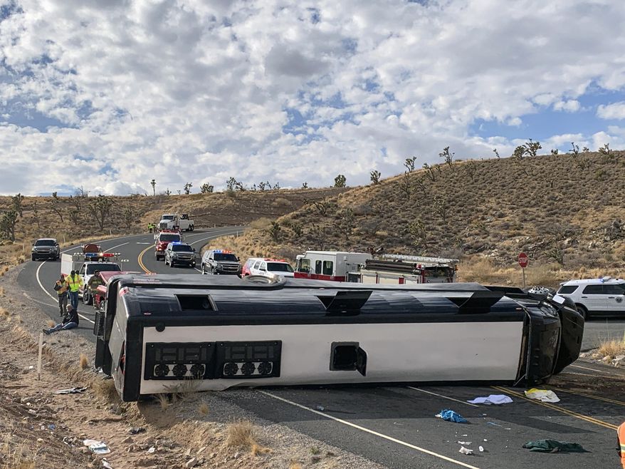 This photo provided by the Mohave County Sheriff's Office shows a Las Vegas-based tour bus that crashed, Jan. 22, 2021, in Dolan Springs, Ariz. A crash report on the tour bus that flipped on the way to the west end of the Grand Canyon, killing one passenger, doesn't draw any conclusion about the cause but points to speed as a factor. Four dozen people from across the country were on the bus operated by Comedy On Deck Tours when it veered into a dirt embankment, over ruts and rocks, and hit Joshua trees Jan. 22. (Mohave County Sheriff's Office via AP)