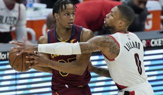Portland Trail Blazers&#39; Damian Lillard (0) defends against Cleveland Cavaliers&#39; Isaac Okoro during the second half of an NBA basketball game Wednesday, May 5, 2021, in Cleveland. (AP Photo/Tony Dejak)