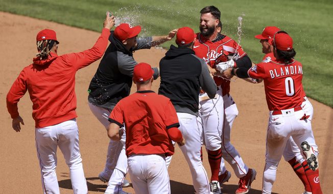 Cincinnati Reds&#x27; Jesse Winker, back right, celebrates with teammates after hitting an RBI walk-off single during the tenth inning of a baseball game against the Chicago White Sox in Cincinnati, Wednesday, May 5, 2021. The Reds won 1-0. (AP Photo/Aaron Doster)