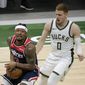 Washington Wizards&#39; Bradley Beal, left, drives to the basket against Milwaukee Bucks&#39; Donte DiVincenzo during the first half of an NBA basketball game Wednesday, May 5, 2021, in Milwaukee. (AP Photo/Aaron Gash)
