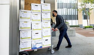 A member of Apple&#x27;s legal team rolls exhibit boxes into the Ronald V. Dellums building in Oakland, Calif., as the company faces off in federal court against Epic Games on Monday, May 3, 2021. Epic, maker of the video game Fortnite, charges that Apple has transformed its App Store into an illegal monopoly. (AP Photo/Noah Berger)