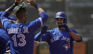 Toronto Blue Jays&#39; Marcus Semien, right, celebrates with Lourdes Gurriel Jr. (13) after hitting a solo home run against the Oakland Athletics during the seventh inning of a baseball game in Oakland, Calif., Thursday, May 6, 2021. (AP Photo/Tony Avelar)