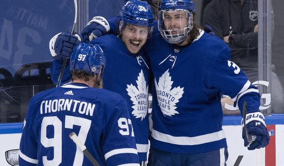 Toronto Maple Leafs center Auston Matthews (34) celebrates his 40th goal of the season with teammates Joe Thornton (97) and Justin Holl (3), during the third period of an NHL hockey game against the Montreal Canadiens on Thursday, May, 6, 2021, in Toronto. (Frank Gunn/The Canadian Press via AP)