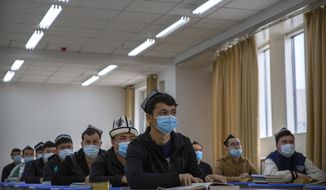 In this file photo, Uyghurs and other students listen to an instructor during a class at the Xinjiang Islamic Institute, as seen during a government organized visit for foreign journalists, in Urumqi in western China&#x27;s Xinjiang Uyghur Autonomous Region on April 22, 2021.  (AP Photo/Mark Schiefelbein)
