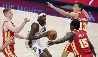 Indiana Pacers&#39; Caris LeVert (22) looks for a shot between Atlanta Hawks&#39; Bogdan Bogdanovic (13), Clint Capela (15) and Kevin Huerter during the second half of an NBA basketball game Thursday, May 6, 2021, in Indianapolis. (AP Photo/Darron Cummings)