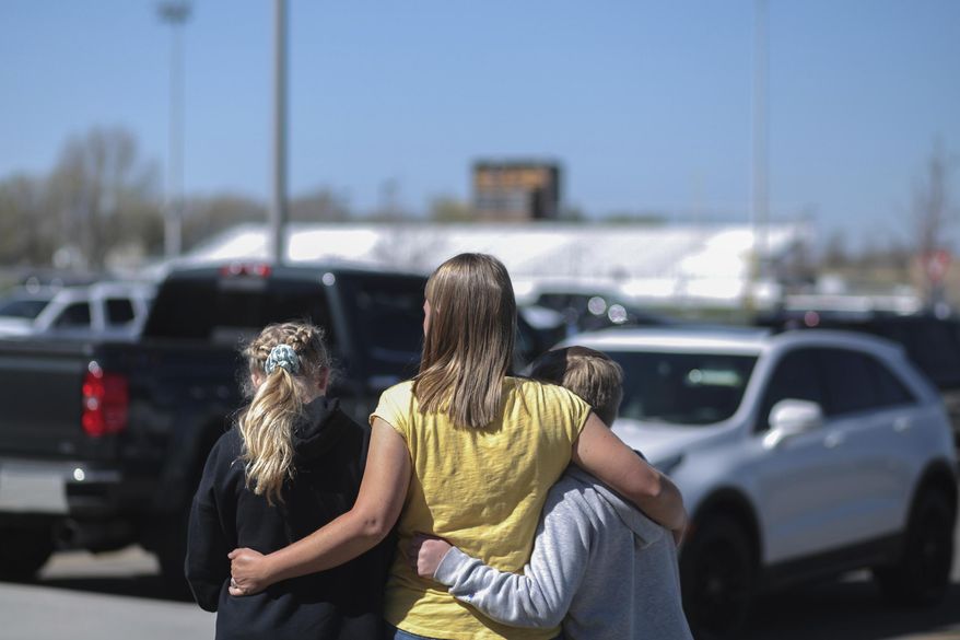 People embrace outside after a shooting at Rigby Middle School in Rigby, Idaho on Thursday, May 6, 2021.  Authorities say a shooting at the eastern Idaho middle school has injured two students and a custodian, and a male student has been taken into custody. (John Roark /The Idaho Post-Register via AP)