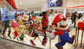FILE - In this Jan. 23, 2020, file photo, Nintendo characters, including Mario, right, are seen on a glass of its official store in Tokyo. Nintendo Co.’s profit for the fiscal year ended in March jumped 86% on healthy sales of the Switch handheld machine as people staying at home over the pandemic turned to video games. (AP Photo/Jae C. Hong, File)