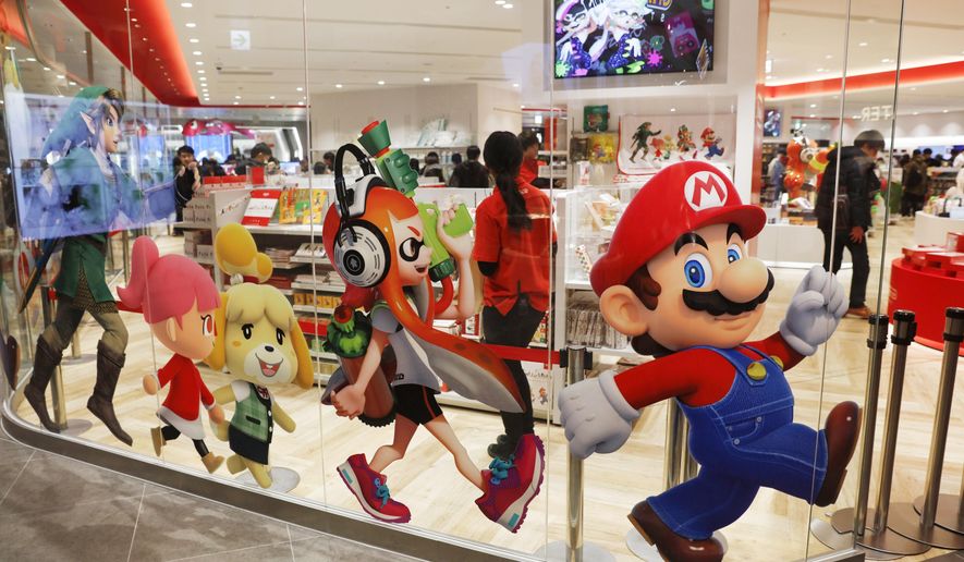 FILE - In this Jan. 23, 2020, file photo, Nintendo characters, including Mario, right, are seen on a glass of its official store in Tokyo. Nintendo Co.’s profit for the fiscal year ended in March jumped 86% on healthy sales of the Switch handheld machine as people staying at home over the pandemic turned to video games. (AP Photo/Jae C. Hong, File)