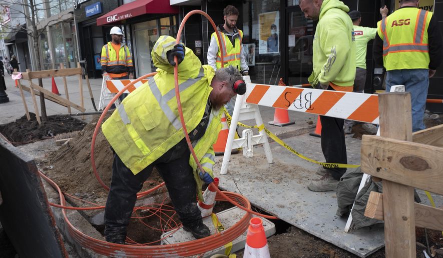 FILE - In this April 21, 2021 file photo, workers install conduit that will hold Verizon&#39;s fiber-optic cable in New York.   U.S. productivity posted a sharp rebound in the January-March quarter after having fallen in the previous quarter. Labor costs declined slightly.  (AP Photo/Mark Lennihan)
