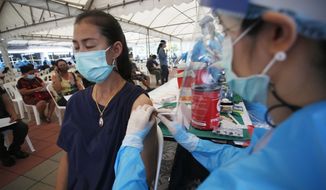 FILE - In this Tuesday, May 4, 2021, file photo, a health worker administers a dose of the Sinovac COVID-19 vaccine to residents of the Klong Toey area, a neighborhood currently having a spike in coronavirus cases, in Bangkok, Thailand. Thailand sought Thursday, may 6, 2021, to assure its foreign residents that they can get COVID-19 vaccinations, countering comments by some officials suggesting they would be at the end of the line for inoculations. (AP Photo/Anuthep Cheysakron)