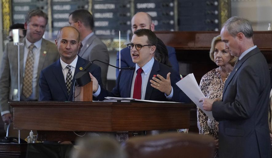 Rep. Briscoe Cain, R-Houston, center, stands with co-sponsors as he answers questions and speaks in favor of HB 6, an election bill, in the House Chamber at the Texas Capitol in Austin, Texas, Thursday, May 6, 2021. (AP Photo/Eric Gay)