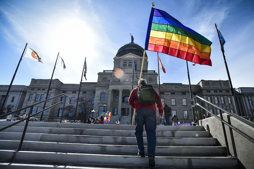 FILE - In this March 15, 2021, file photo demonstrators gather on the steps of the Montana State Capitol protesting anti-LGBTQ+ legislation in Helena, Mont. Gov. Greg Gianforte signed a bill Friday, May 7, 2021, banning transgender athletes from participating in school and university sports according to the gender with which they identify, making Montana the latest of several Republican-controlled states to approve such measures this year. (Thom Bridge/Independent Record via AP, File)