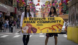 Dr. Michelle Lee, left, a radiology resident, and Ida Chen, right, a physician assistant student, unfold a banner Lee created to display at rallies protesting anti-Asian hate, Saturday April 24, 2021, in New York&#x27;s Chinatown.  (AP Photo/Bebeto Matthews)