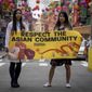 Dr. Michelle Lee, left, a radiology resident, and Ida Chen, right, a physician assistant student, unfold a banner Lee created to display at rallies protesting anti-Asian hate, Saturday April 24, 2021, in New York&#39;s Chinatown.  (AP Photo/Bebeto Matthews)