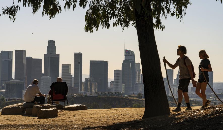 In this Monday, Jan. 11, 2021, file photo, people overlook the skyline of Los Angeles. California's population has declined for the first time in its history. State officials announced Friday, May 7 that the nation's most populous state lost 182,083 people in 2020. California's population is now just under 39.5 million. (AP Photo/Damian Dovarganes, File)