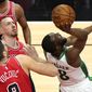 Boston Celtics guard Kemba Walker, right, shoots as Chicago Bulls center Nikola Vucevic and center Daniel Theis watch the ball during the first half of an NBA basketball game in Chicago, Friday, May 7, 2021. (AP Photo/Nam Y. Huh)
