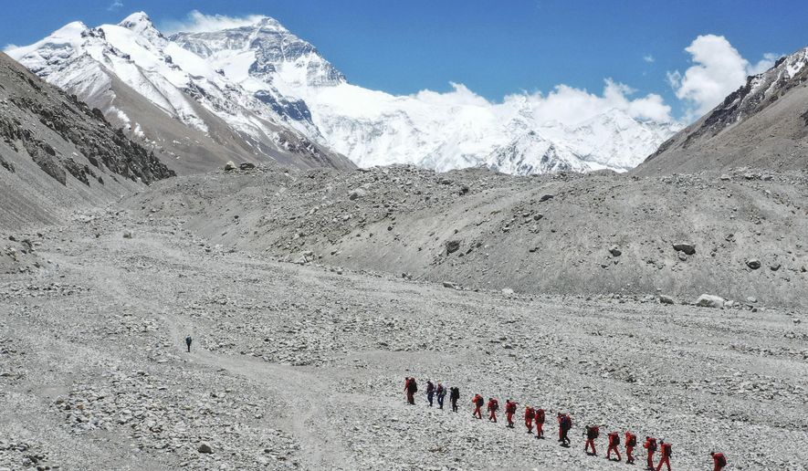 FILE - In this May 16, 2020, file photo released by Xinhua News Agency, Chinese surveyors hike toward a higher spot from the base camp on Mount Qomolangma at an altitude of 5,200 meters. China has opened the spring Everest claiming season from the northern approach amid strict measures to prevent the spread of COVID-19. A total of 38 people have been issued permits to climb the world’s highest peak, known as Qomolongma in Tibetan, between March 31 and May 20, state media reported Friday, May 7, 2021. (Jigme Dorje/Xinhua via AP, File)