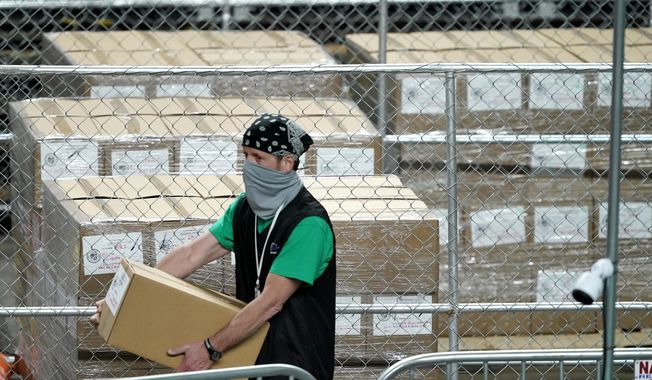 Maricopa County ballots cast in the 2020 general election are fenced in a secure area as a box is delivered to be examined and recounted by contractors working for Florida-based company, Cyber Ninjas, Thursday, May 6, 2021, at Veterans Memorial Coliseum in Phoenix. (AP Photo/Matt York, Pool) ** FILE **