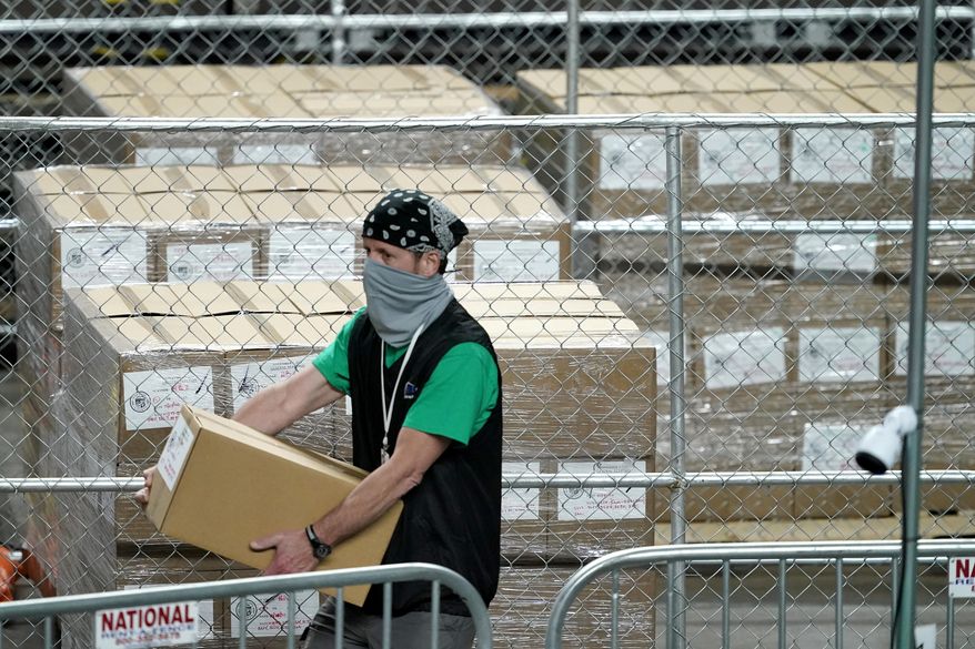 Maricopa County ballots cast in the 2020 general election are fenced in a secure area as a box is delivered to be examined and recounted by contractors working for Florida-based company, Cyber Ninjas, Thursday, May 6, 2021, at Veterans Memorial Coliseum in Phoenix. (AP Photo/Matt York, Pool) ** FILE **