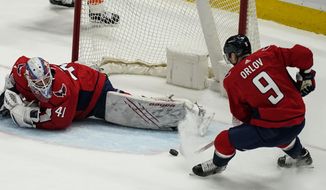 Washington Capitals defenseman Dmitry Orlov (9) clears the puck from in front of goaltender Vitek Vanecek (41) during the first period of an NHL hockey game against the Philadelphia Flyers, Friday, May 7, 2021, in Washington. (AP Photo/Alex Brandon)