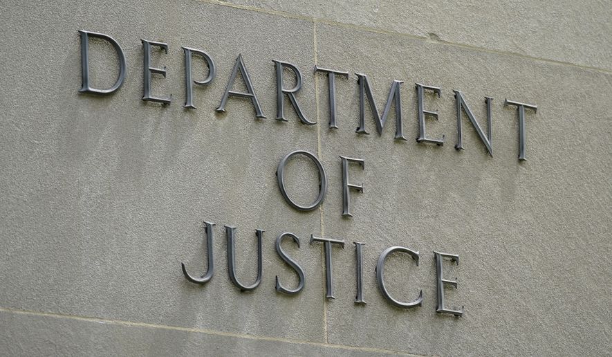 This May 4, 2021, photo shows a sign outside the Robert F. Kennedy Department of Justice building in Washington. The Trump Justice Department secretly seized the phone records of three Washington Post reporters who covered the federal investigation into ties between Russia and Donald Trump&#x27;s campaign, the newspaper said Friday, May 7. (AP Photo/Patrick Semansky)