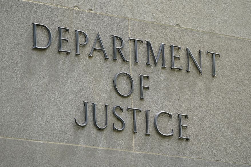This May 4, 2021, photo shows a sign outside the Robert F. Kennedy Department of Justice building in Washington. The Trump Justice Department secretly seized the phone records of three Washington Post reporters who covered the federal investigation into ties between Russia and Donald Trump&#39;s campaign, the newspaper said Friday, May 7. (AP Photo/Patrick Semansky)