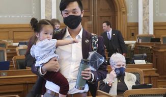 Kansas state Rep. Rui Xu, D-Westwood, holds his 18-month-old daughter, Astra, during a break in the House&#39;s work, Friday, May 7, 2021, at the Statehouse in Topeka, Kan. Lawmakers are working late as they tried to finish their business for the year. (AP Photo/John Hanna)