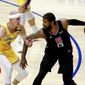 Los Angeles Clippers&#39; Paul George (13) is defended by Los Angeles Lakers&#39; Alex Caruso (4) during the first half of an NBA basketball game Thursday, May 6, 2021, in Los Angeles. (AP Photo/Ringo H.W. Chiu)