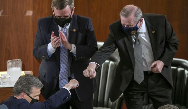 Sen. Phil Berger, right, fist bumps North Carolina Gov. Roy Cooper after Cooper delivered his State of the State address before a joint session of the North Carolina House and Senate, Monday, April 26, 2021, in Raleigh, N.C. (Robert Willett/The News &amp;amp; Observer via AP)