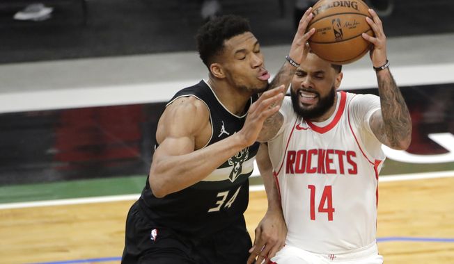 Houston Rockets&#x27; D.J. Augustin (14) drives to the basket against Milwaukee Bucks&#x27; Giannis Antetokounmpo (34) during the first half of an NBA basketball game Friday, May 7, 2021, in Milwaukee. (AP Photo/Aaron Gash)
