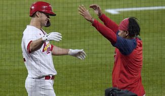 St. Louis Cardinals&#39; Jack Flaherty, left, gets a hug from teammate Carlos Martinez after hitting a solo home run during the third inning of a baseball game against the Colorado Rockies Friday, May 7, 2021, in St. Louis. (AP Photo/Jeff Roberson)