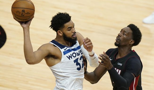 Minnesota Timberwolves center Karl-Anthony Towns (32) looks for an open teammate past Miami Heat center Bam Adebayo during the first half of an NBA basketball game, Friday, May 7, 2021, in Miami. (AP Photo/Wilfredo Lee)