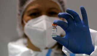 In this Tuesday, Jan. 19, 2021 file photo, a medical worker poses with a vial of the Sinopharm&#39;s COVID-19 vaccine in Belgrade, Serbia.  (AP Photo/Darko Vojinovic, file)  **FILE**