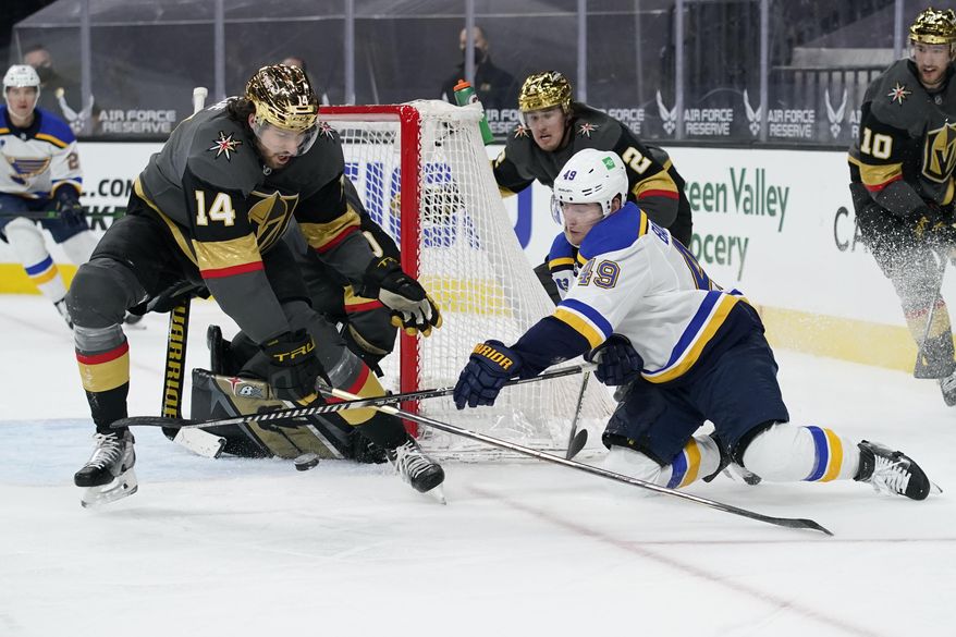 St. Louis Blues center Ivan Barbashev (49) attempts a wrap around shot against Vegas Golden Knights defenseman Nicolas Hague (14) during the third period of an NHL hockey game Friday, May 7, 2021, in Las Vegas. (AP Photo/John Locher)