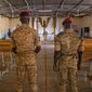Two soldiers stand in the Catholic church at the 10th RCAS army barracks in Kaya, Burkina Faso, Saturday, April 10, 2021. Once considered a beacon of peace and religious coexistence in the region, the West African nation has been embroiled in unprecedented violence linked to al-Qaida and the Islamic State since 2016, throwing an ill-equipped and undertrained army into disarray — and overwhelming the chaplains tasked with supporting them. (AP Photo/Sophie Garcia)
